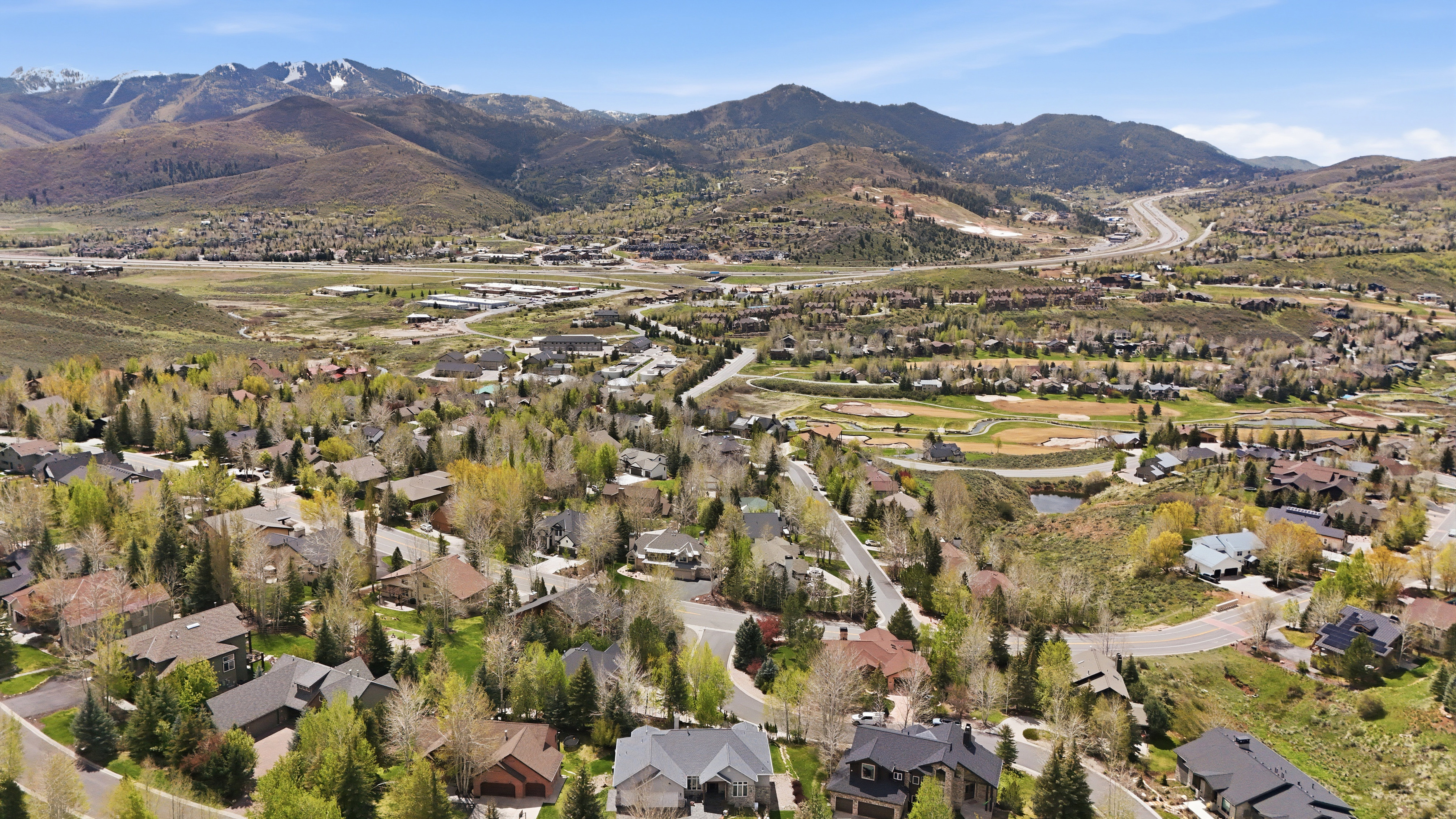 Expansive neighborhood with diverse residential architecture set amidst mature trees and mountainous terrain