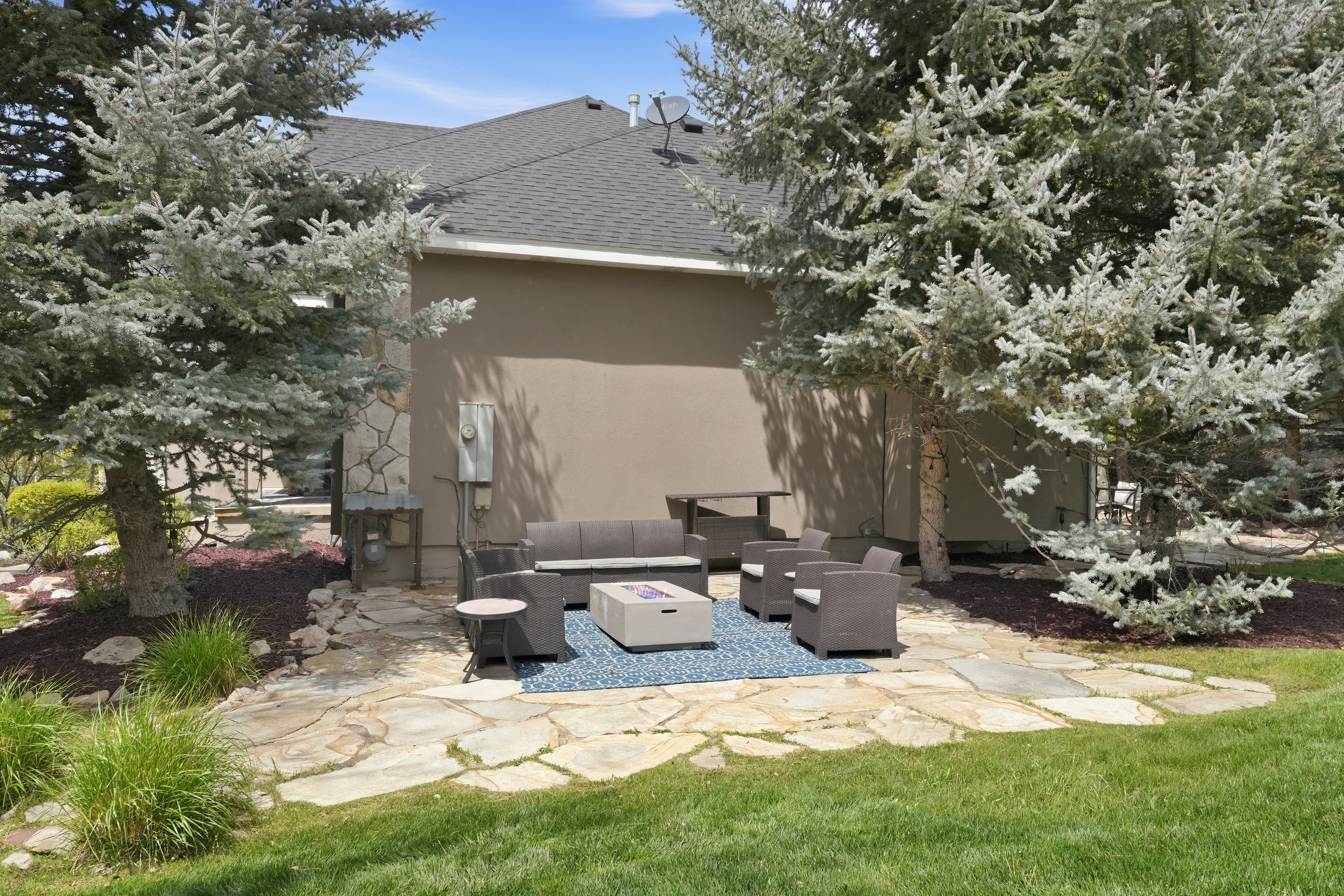 Flagstone patio with a stucco and stone-clad exterior