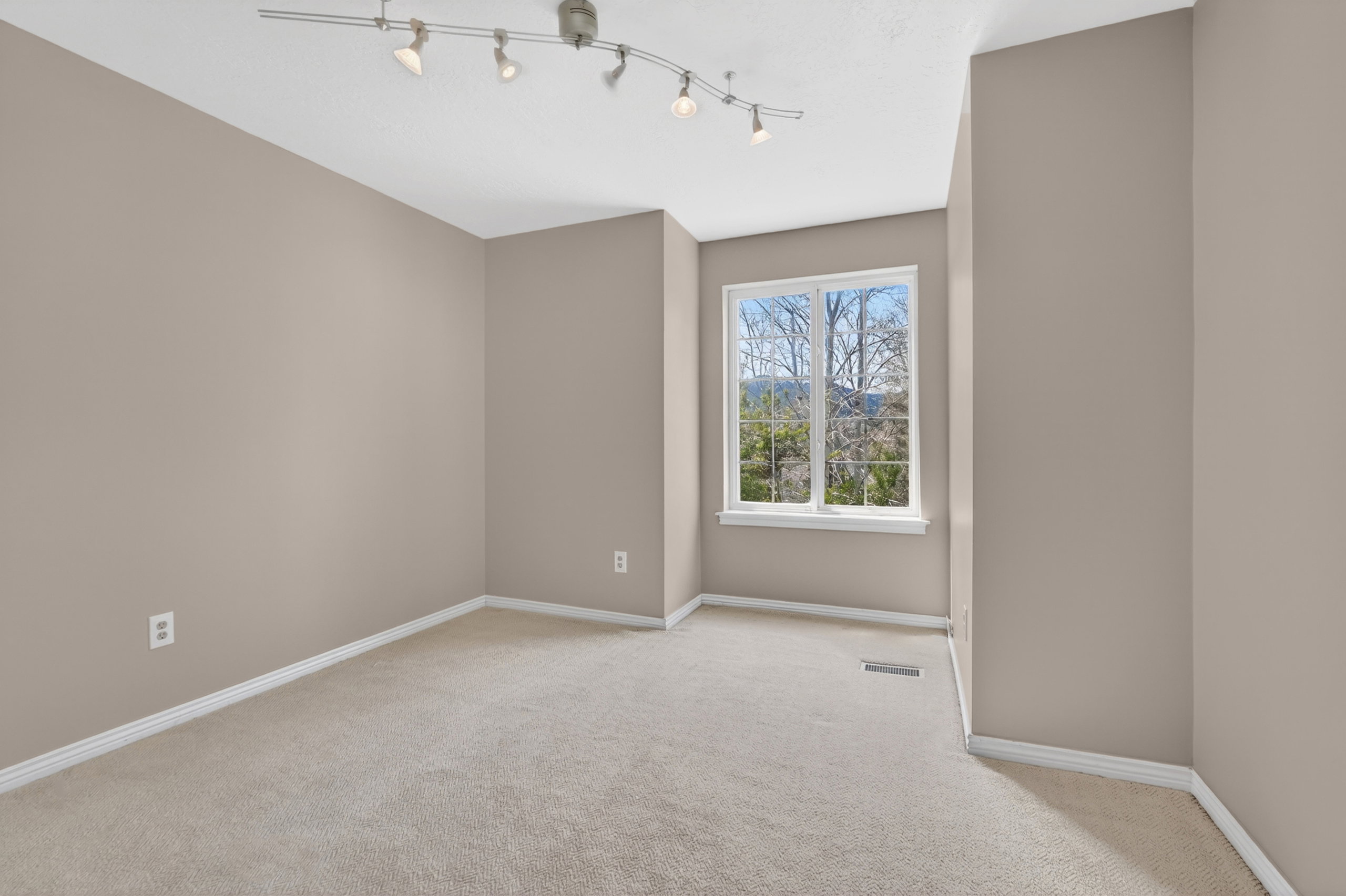 Naturally lit room featuring neutral wall tones and plush carpeting