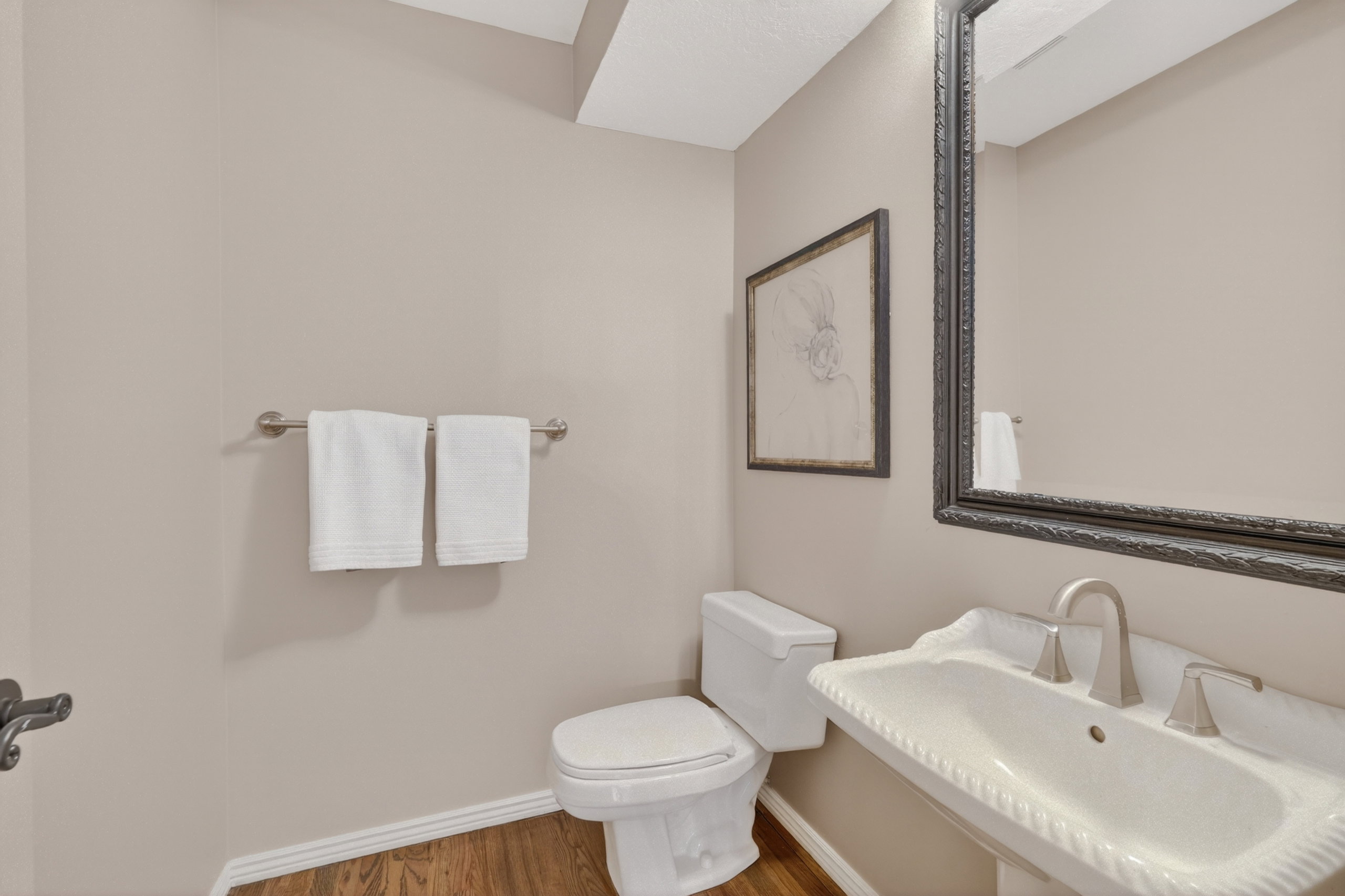 Pedestal sink with rope-edge detailing and a brushed nickel faucet
