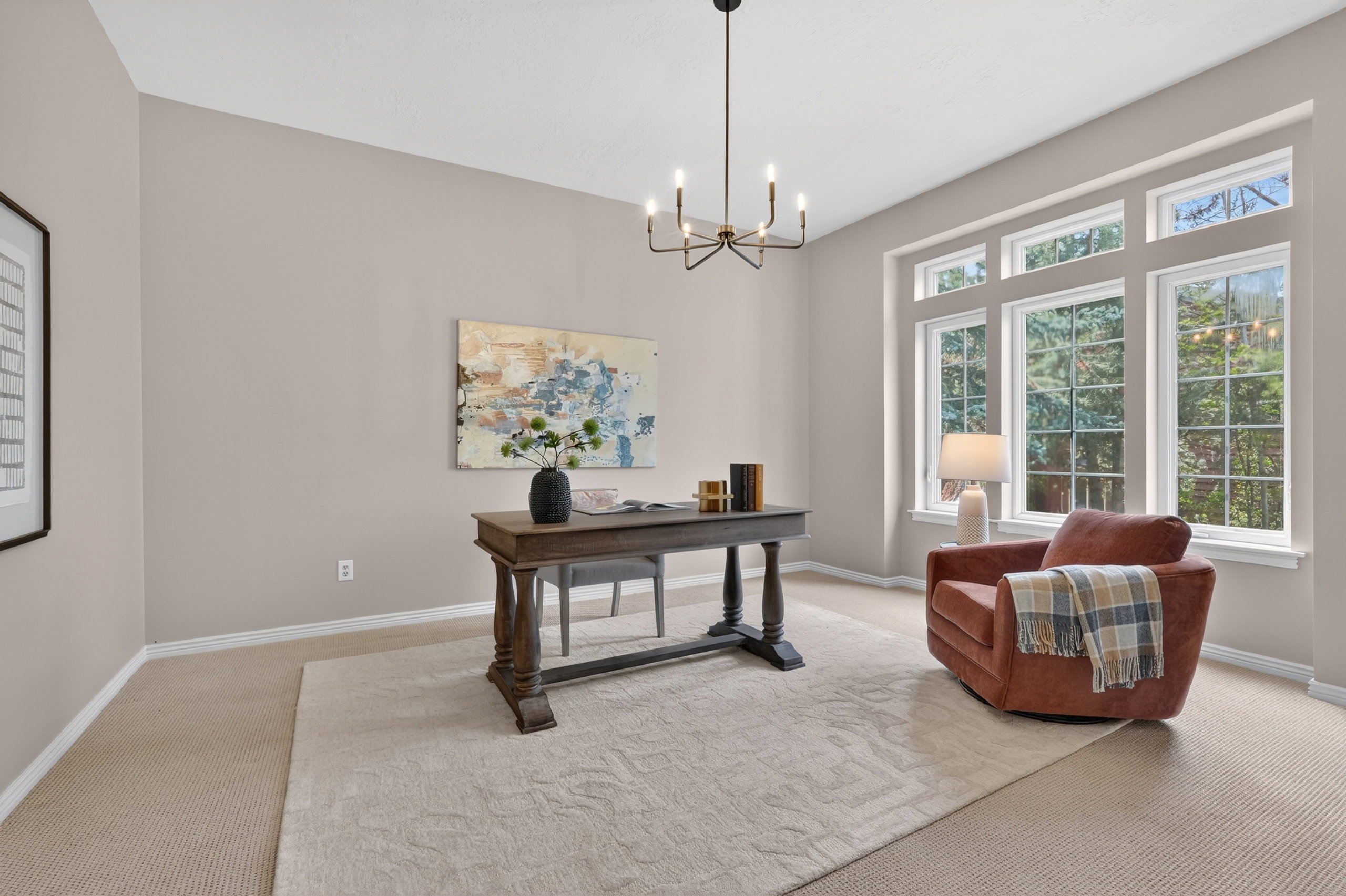 Room featuring expansive multi-pane windows, neutral wall tones, and a contemporary chandelier