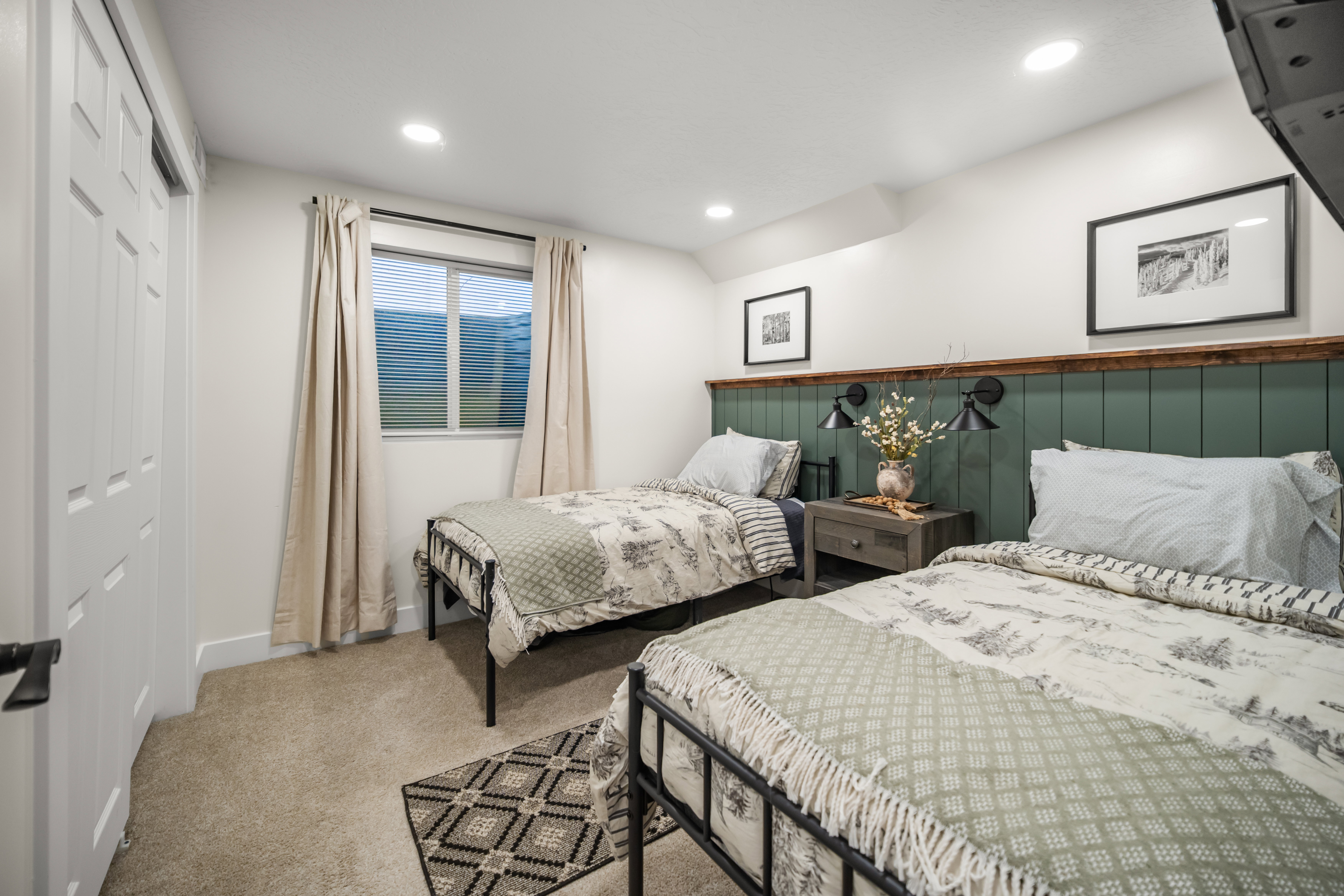 Room featuring a paneled accent wall in a deep green hue, sconce lighting, and recessed ceiling lights