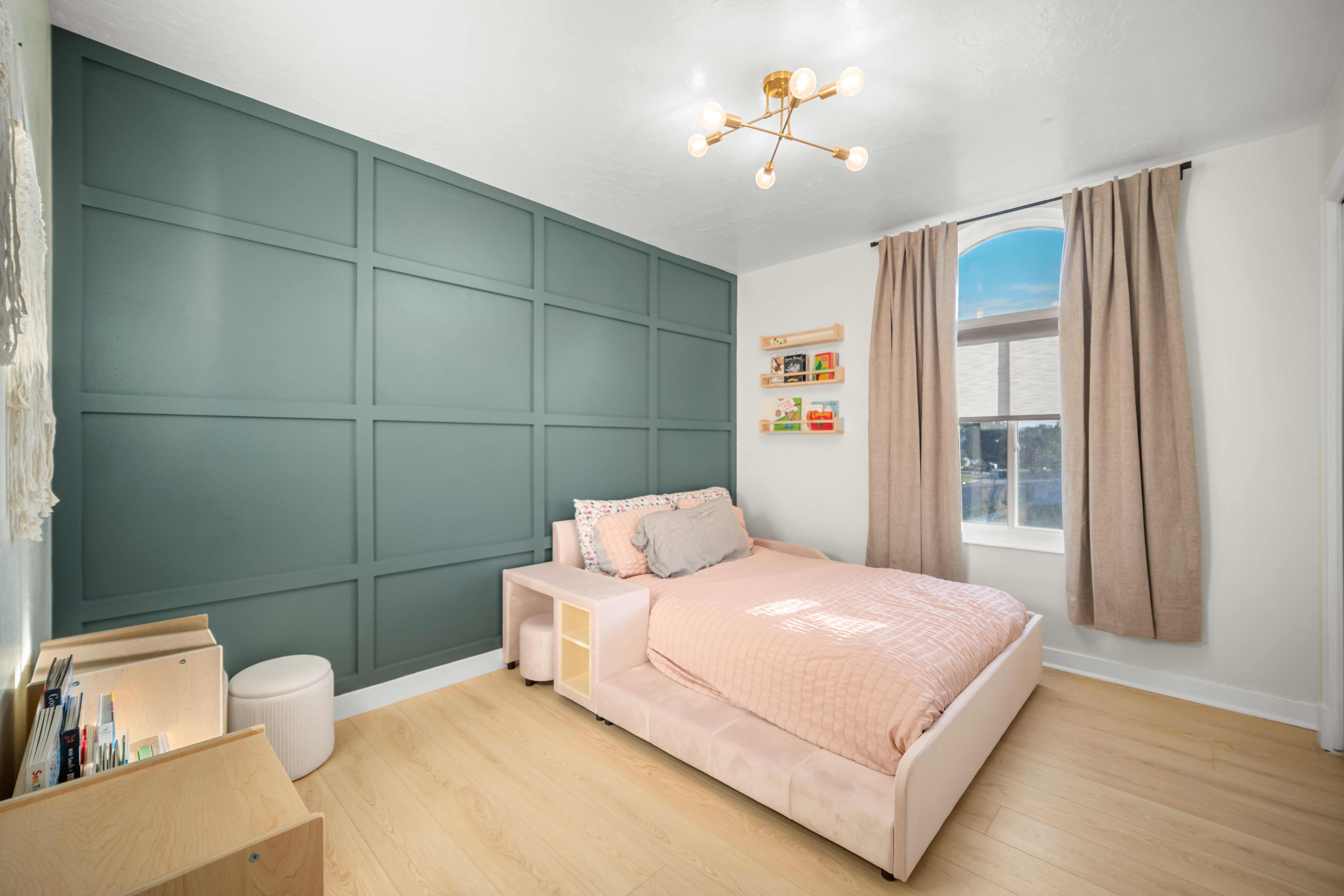 Accent wall featuring board and batten detailing, wood-finish flooring, a contemporary multi-bulb ceiling fixture, an arched window, and built-in floating shelves