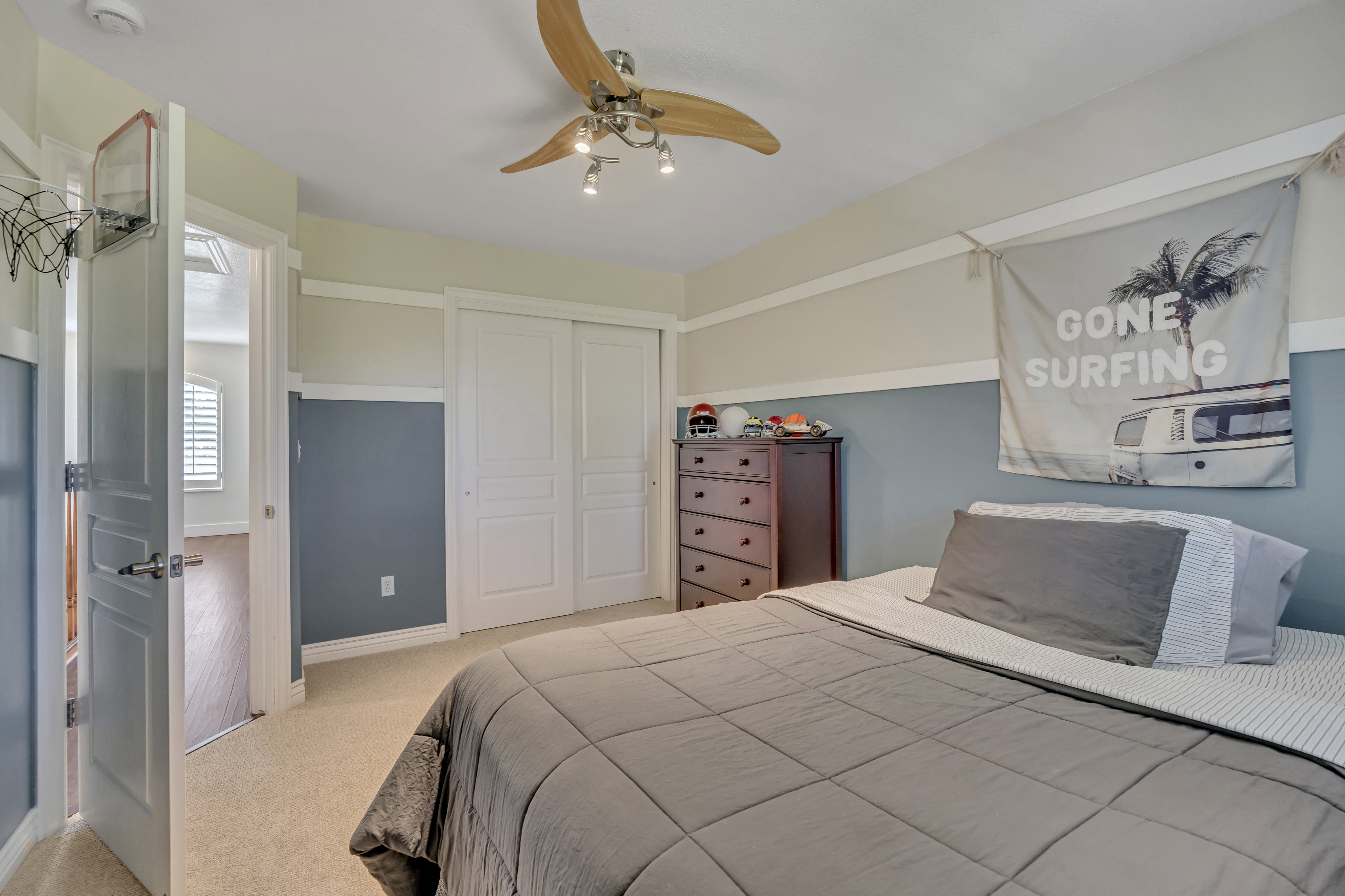 3rd upper level bedroom with a ceiling fan featuring wood-finish blades and track lighting