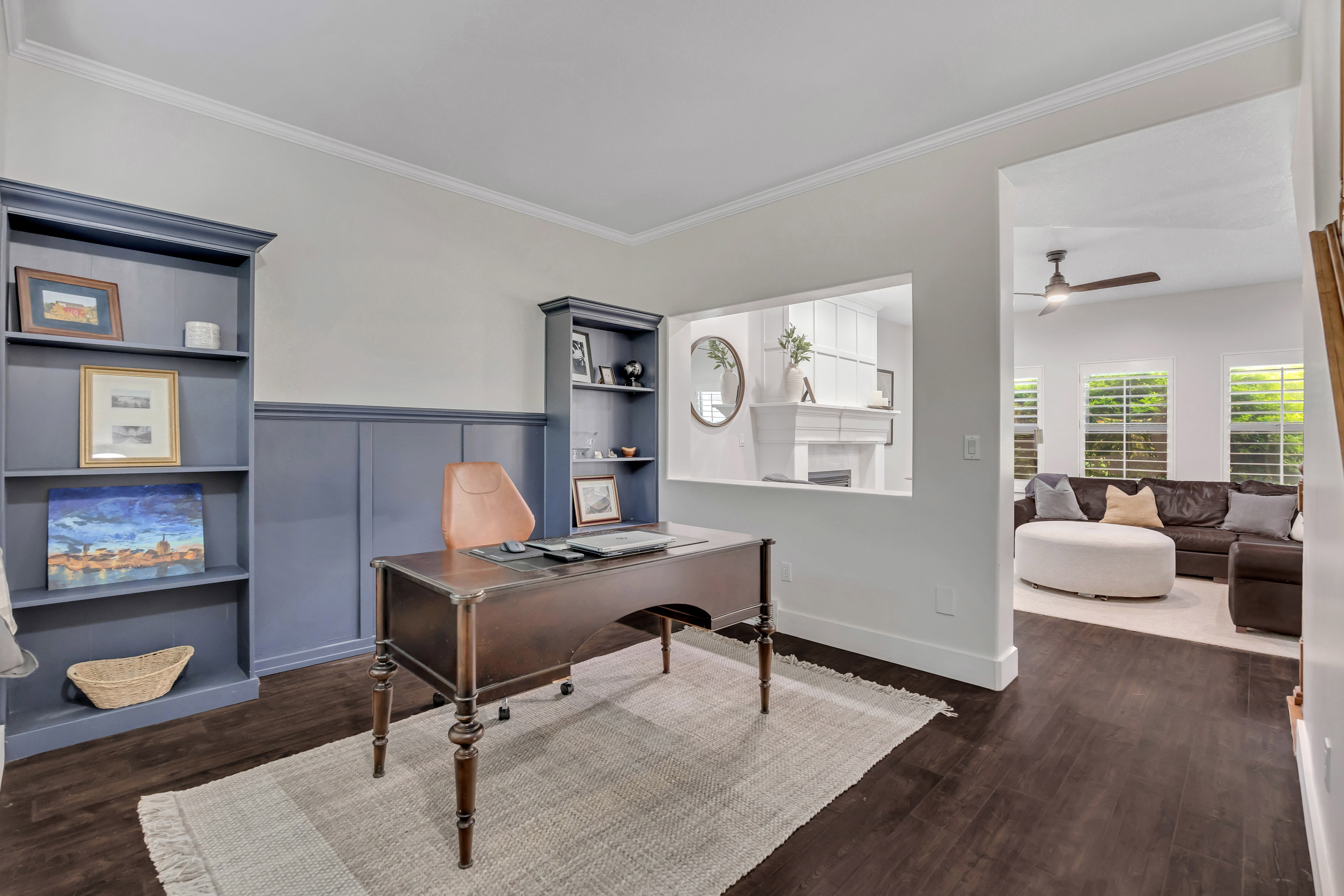 Dedicated room with dark wood-finish flooring, built-in shelving, and wainscoting