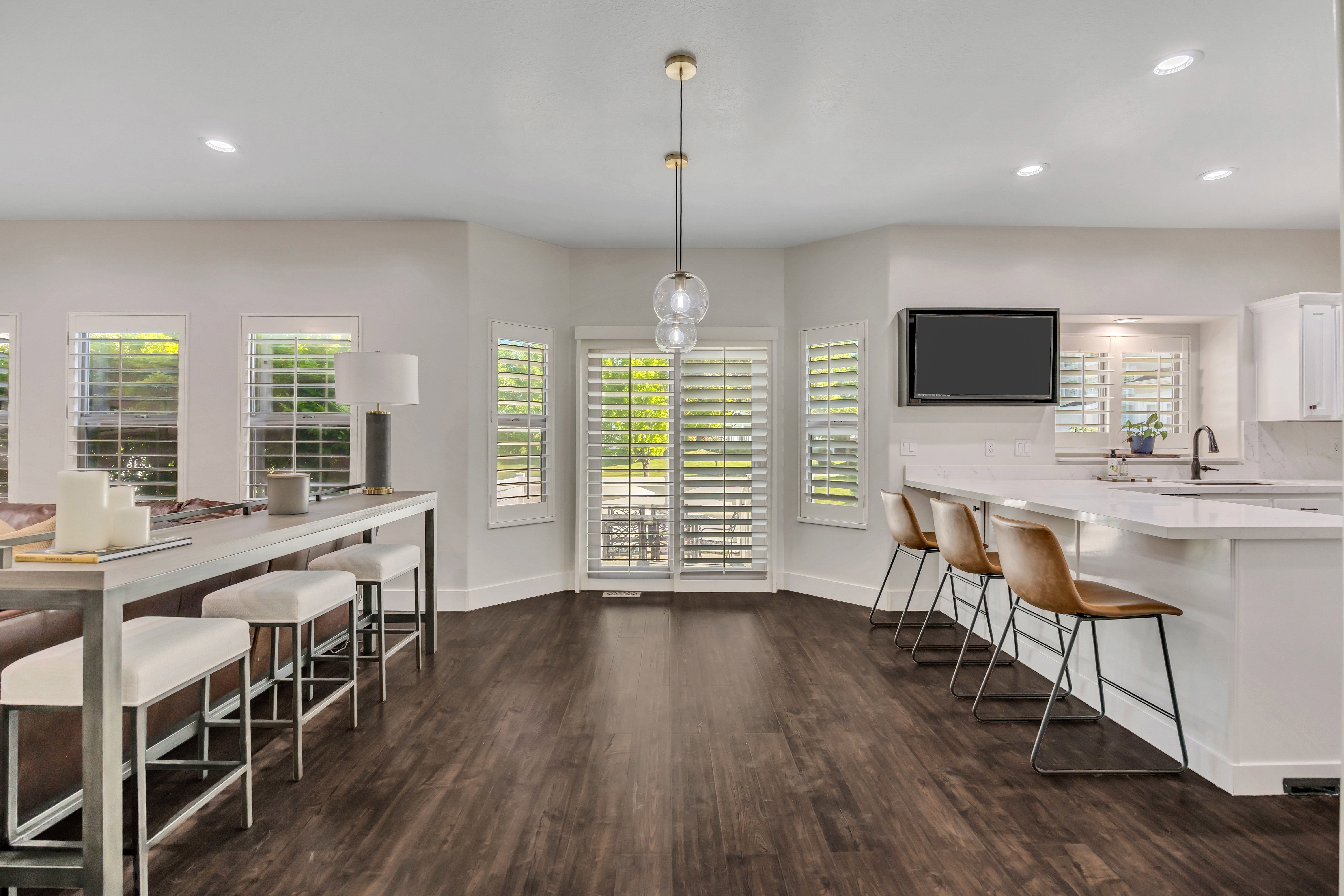 Open-concept living space featuring wood-finish flooring, recessed lighting, and a modern pendant fixture