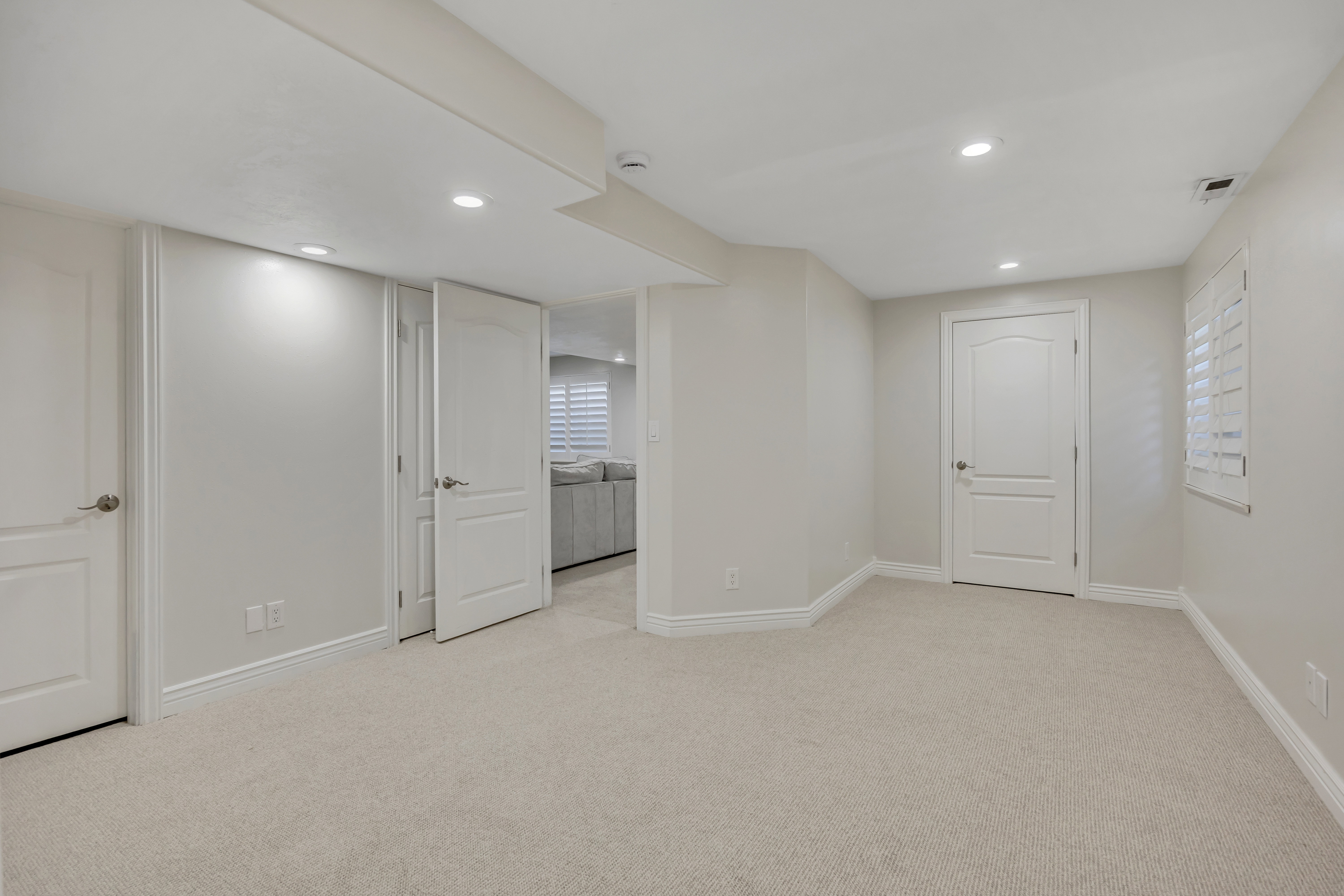Carpeted room with recessed lighting and multiple panel doors