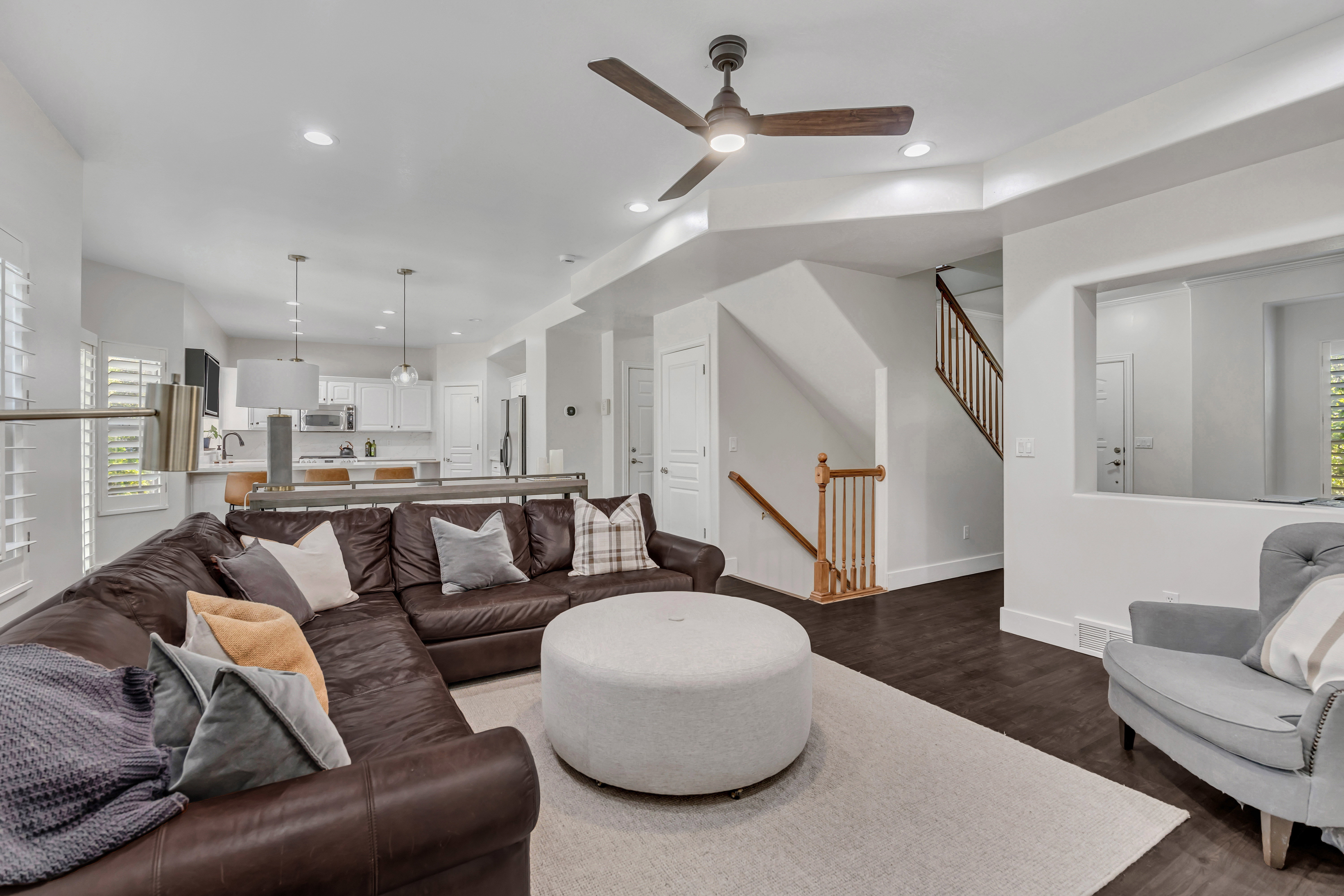 Spacious living area featuring dark wood-finish flooring and a contemporary ceiling fan