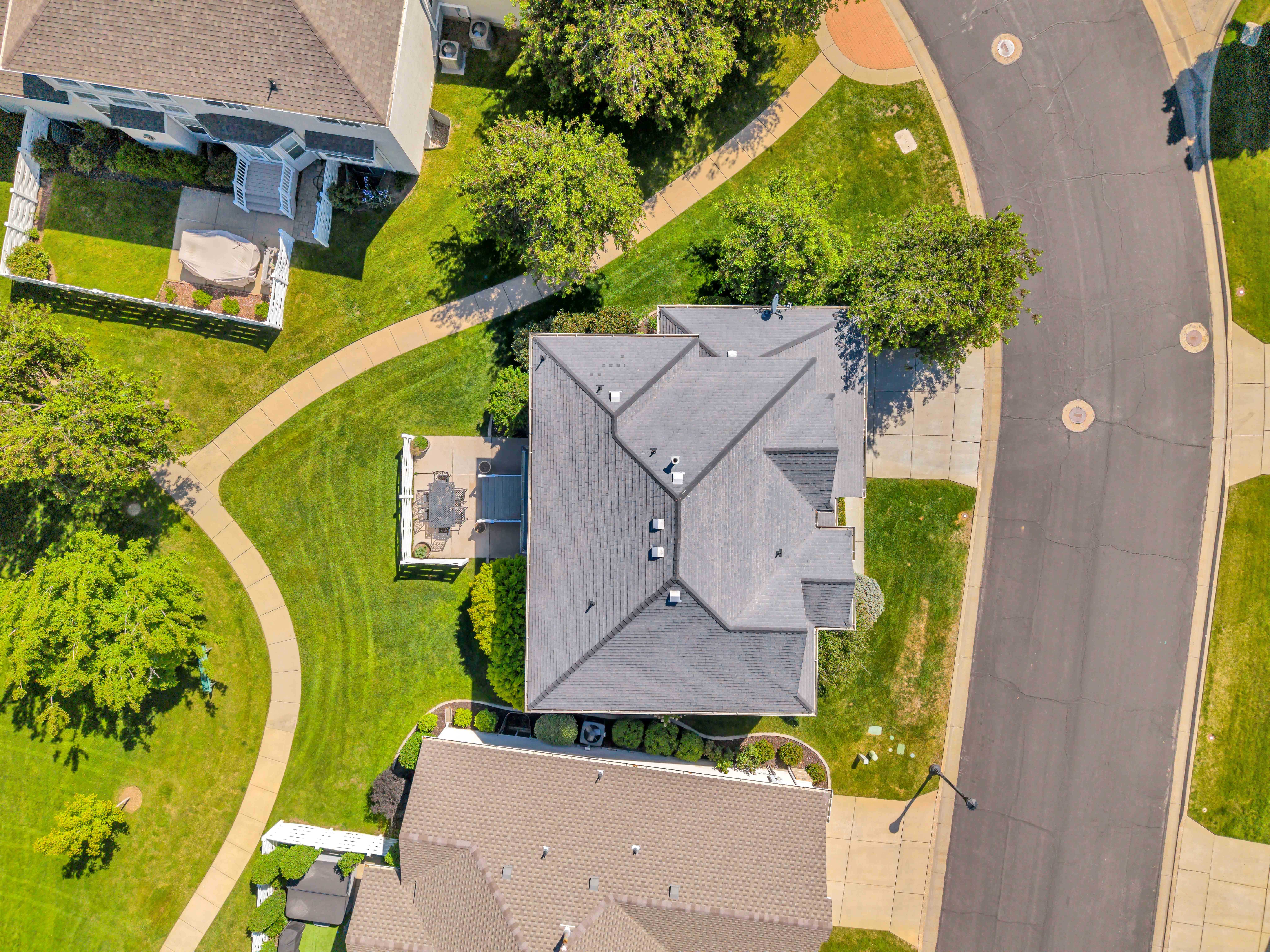 Aerial view of a residential property featuring a multi-gabled shingle roof