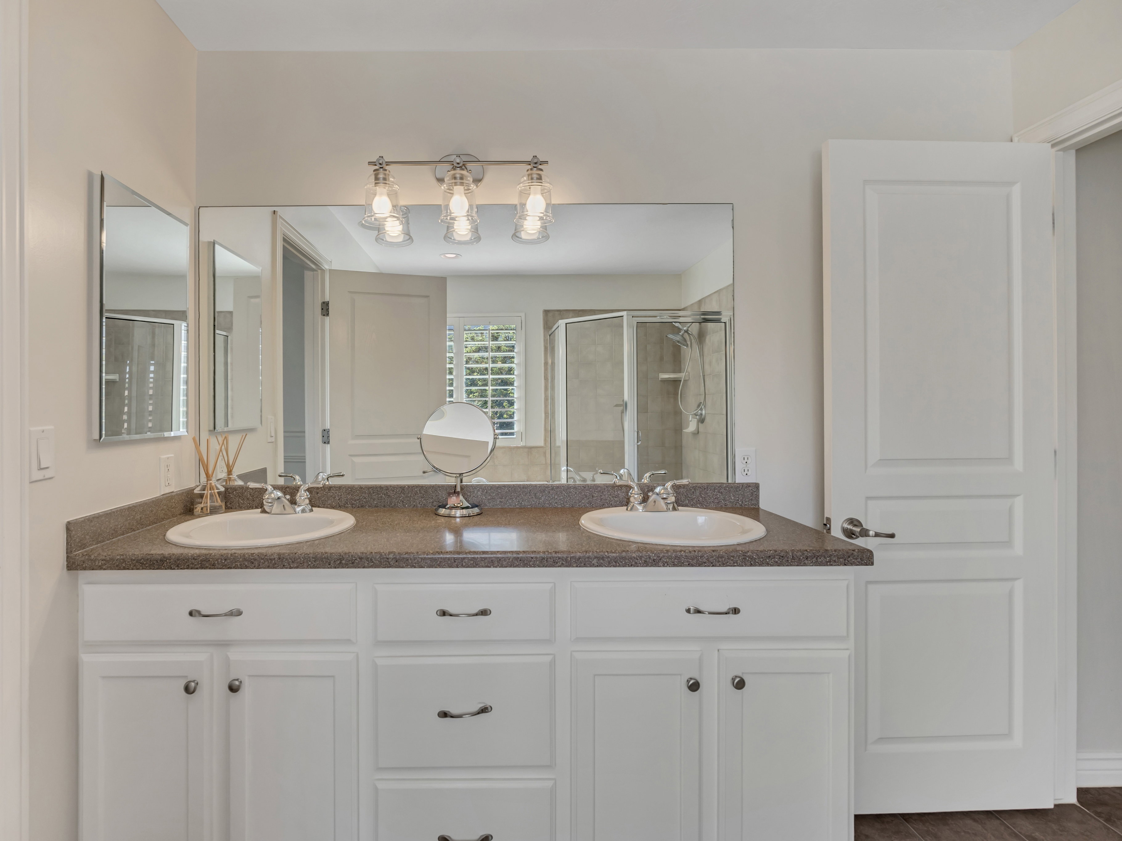 Double vanity featuring white cabinetry, dual undermount sinks, and a speckled countertop