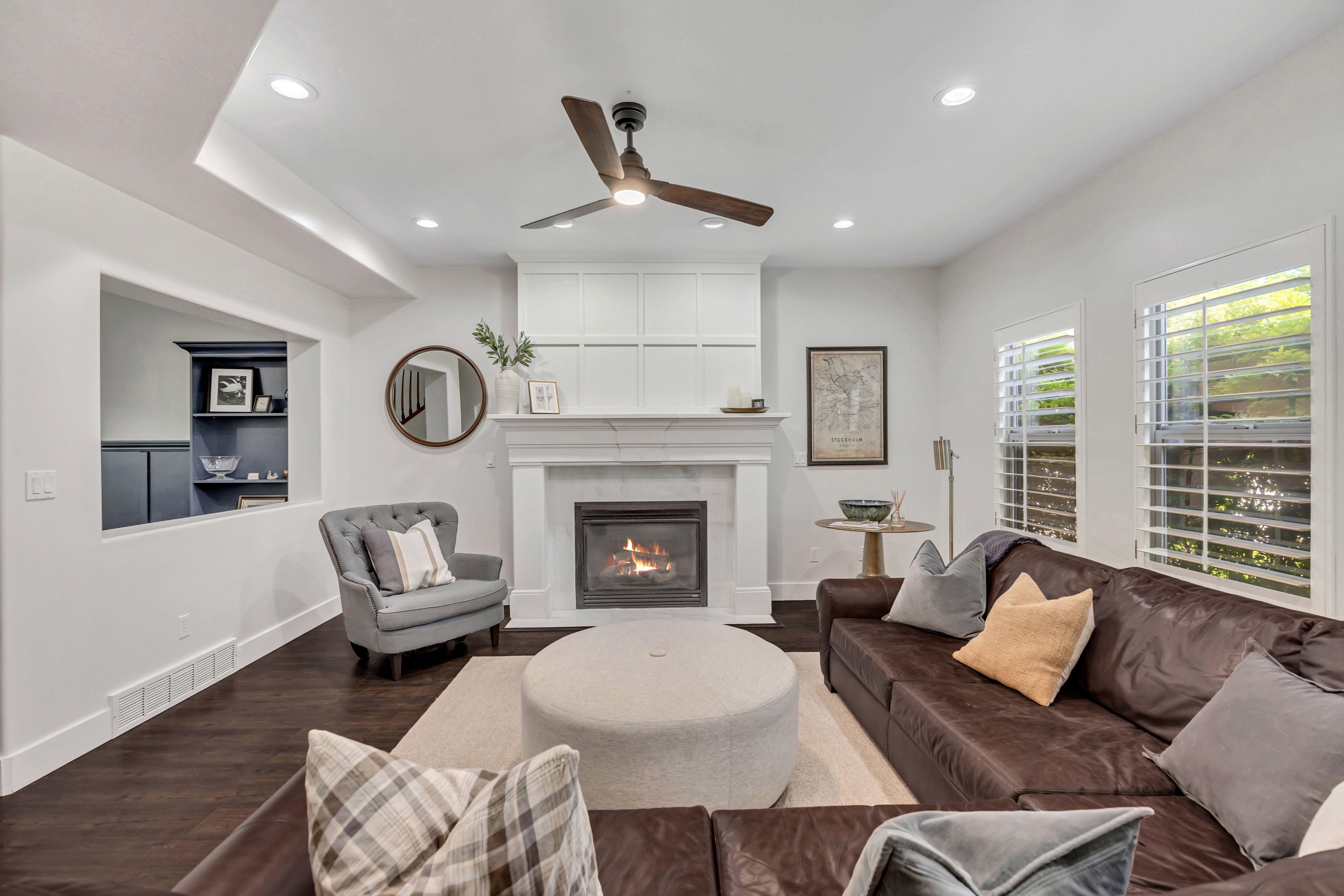 Living area featuring a fireplace with a white mantel and built-in cabinetry
