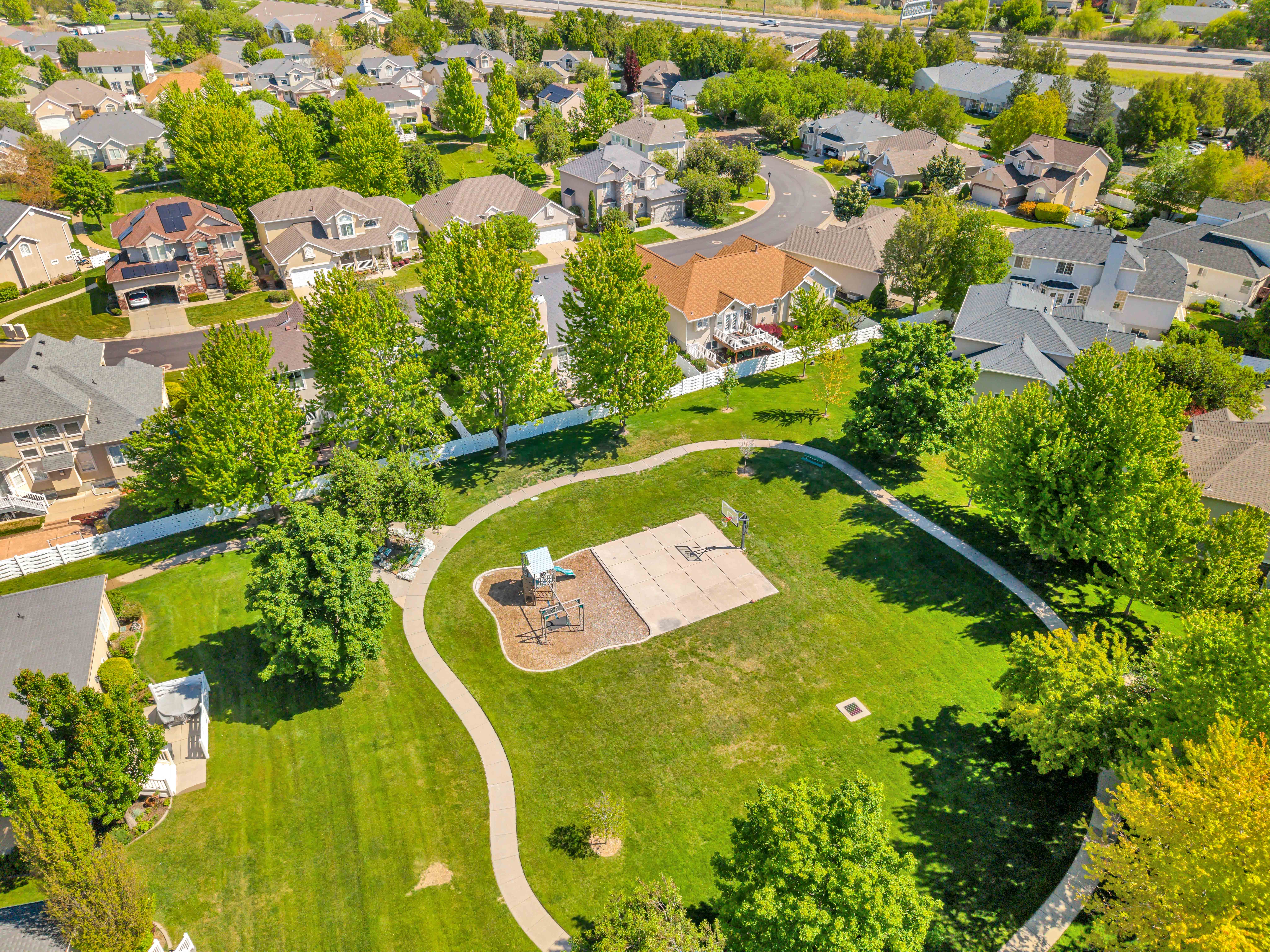 Open Space Park featuring a playground, basketball court, and paved walking path