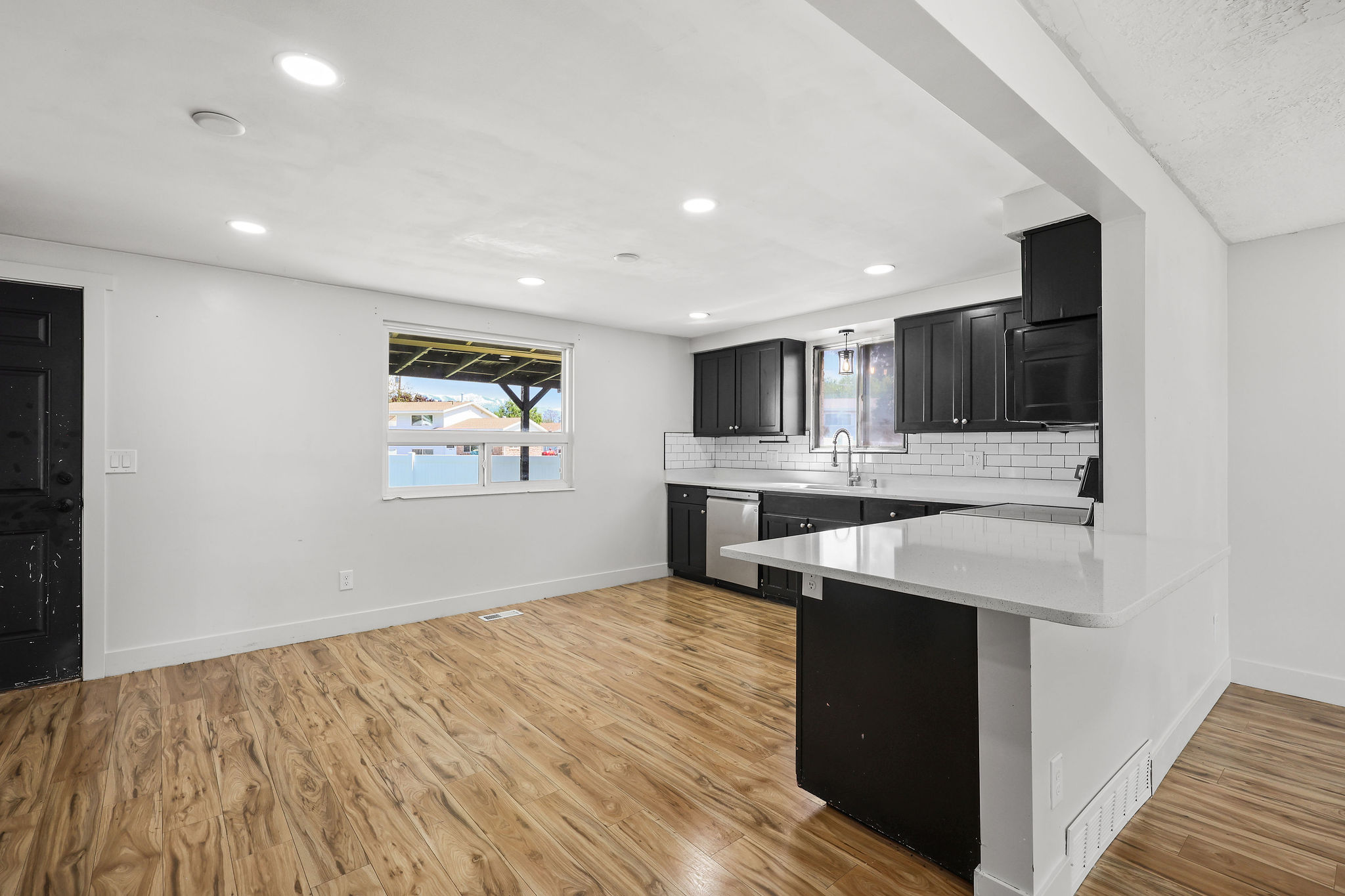 Open-concept living space featuring wood-finish flooring and recessed lighting