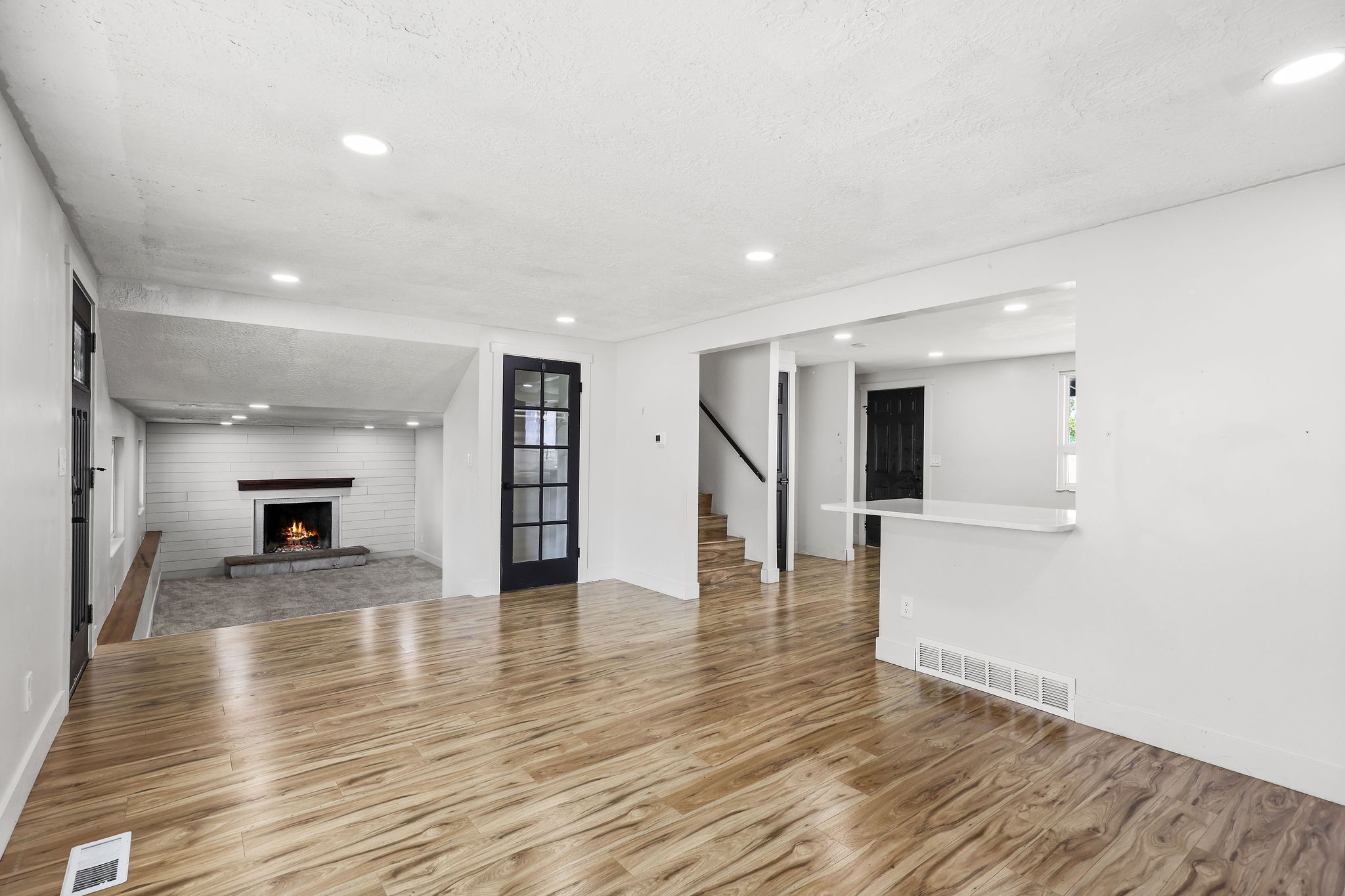 Spacious interior featuring wood-finish flooring, recessed lighting, and white walls