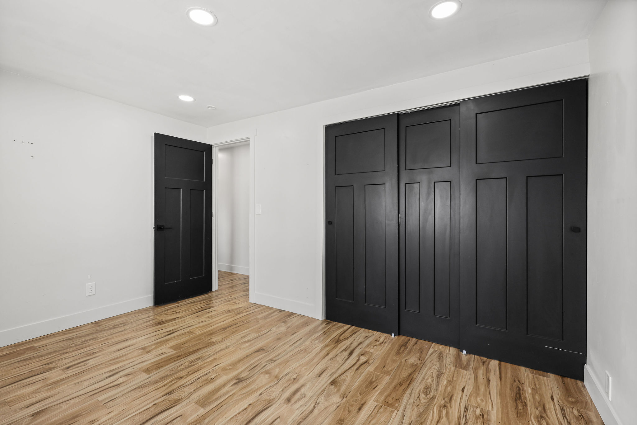 Room featuring wood-finish flooring, recessed ceiling lighting, and crisp white walls