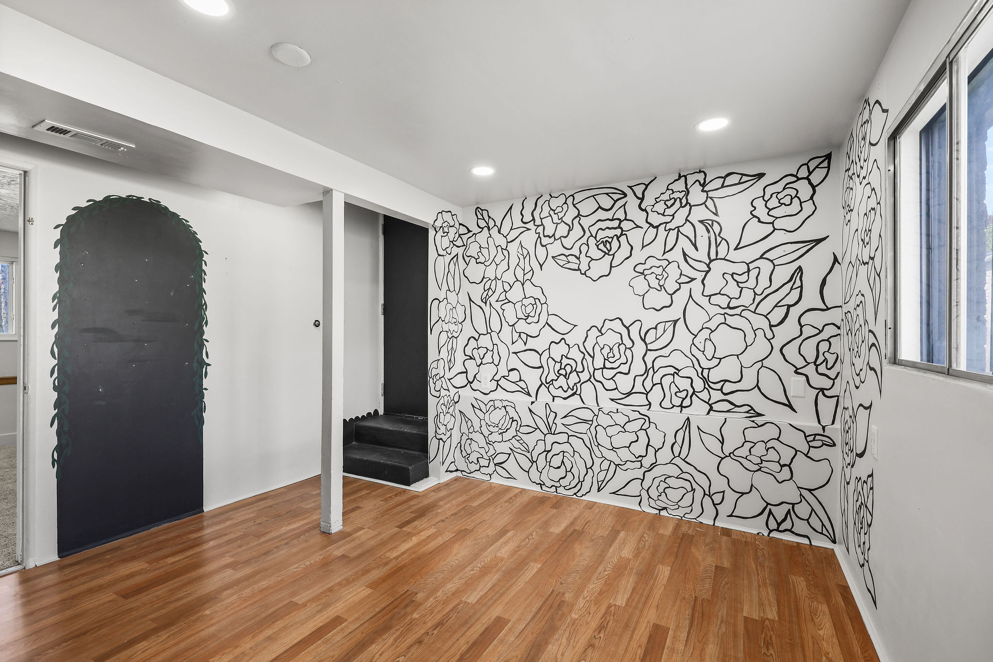 Room featuring wood-finish flooring, recessed lighting, and a decorative floral wall mural