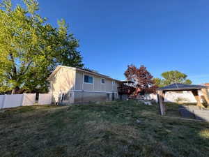 Expansive backyard featuring a multi-level deck with stairs, mature trees, and a white privacy fence