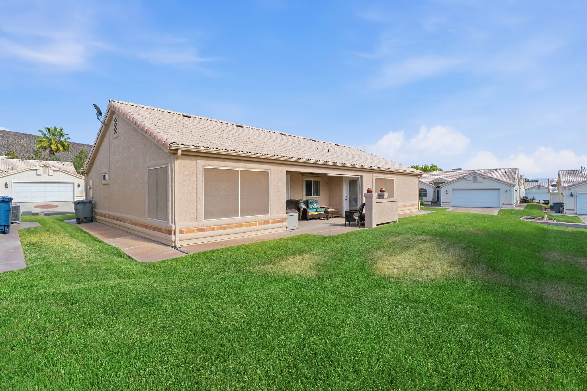 Expansive grassy area with a stucco exterior featuring a tiled roof