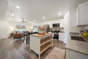 Open-concept living space featuring wood-finish flooring, recessed lighting, and a neutral color palette