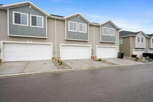 Townhome exteriors featuring light gray stucco and dark gray vertical siding