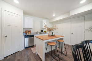 Kitchenette featuring white shaker cabinetry, stainless steel dishwasher, and light granite-style countertops