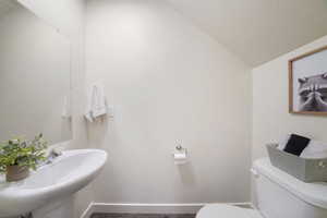 Pedestal sink with chrome faucet and unframed wall-mounted mirror