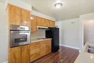 Kitchen featuring wood-finish cabinetry, built-in stainless steel oven, electric cooktop, and laminate countertops