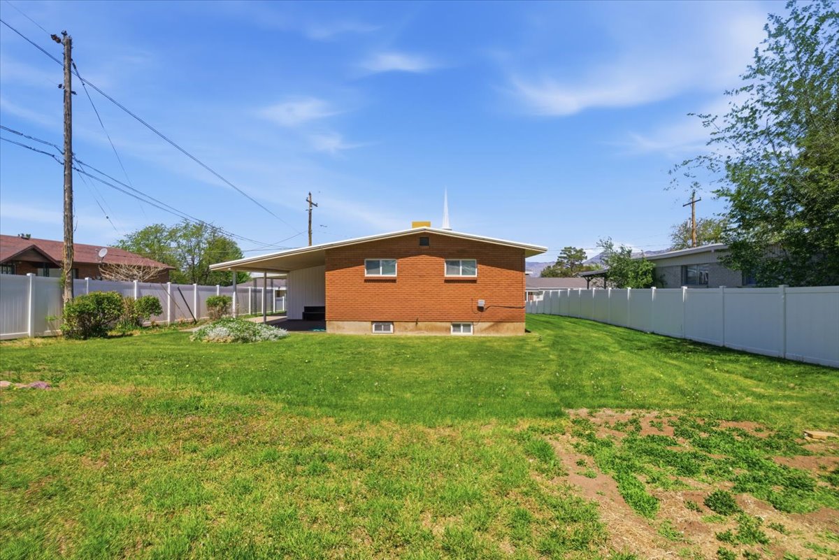 Expansive lawn area bordered by white vinyl fencing