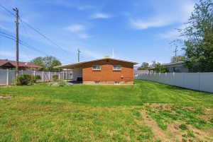 Expansive lawn area bordered by white vinyl fencing