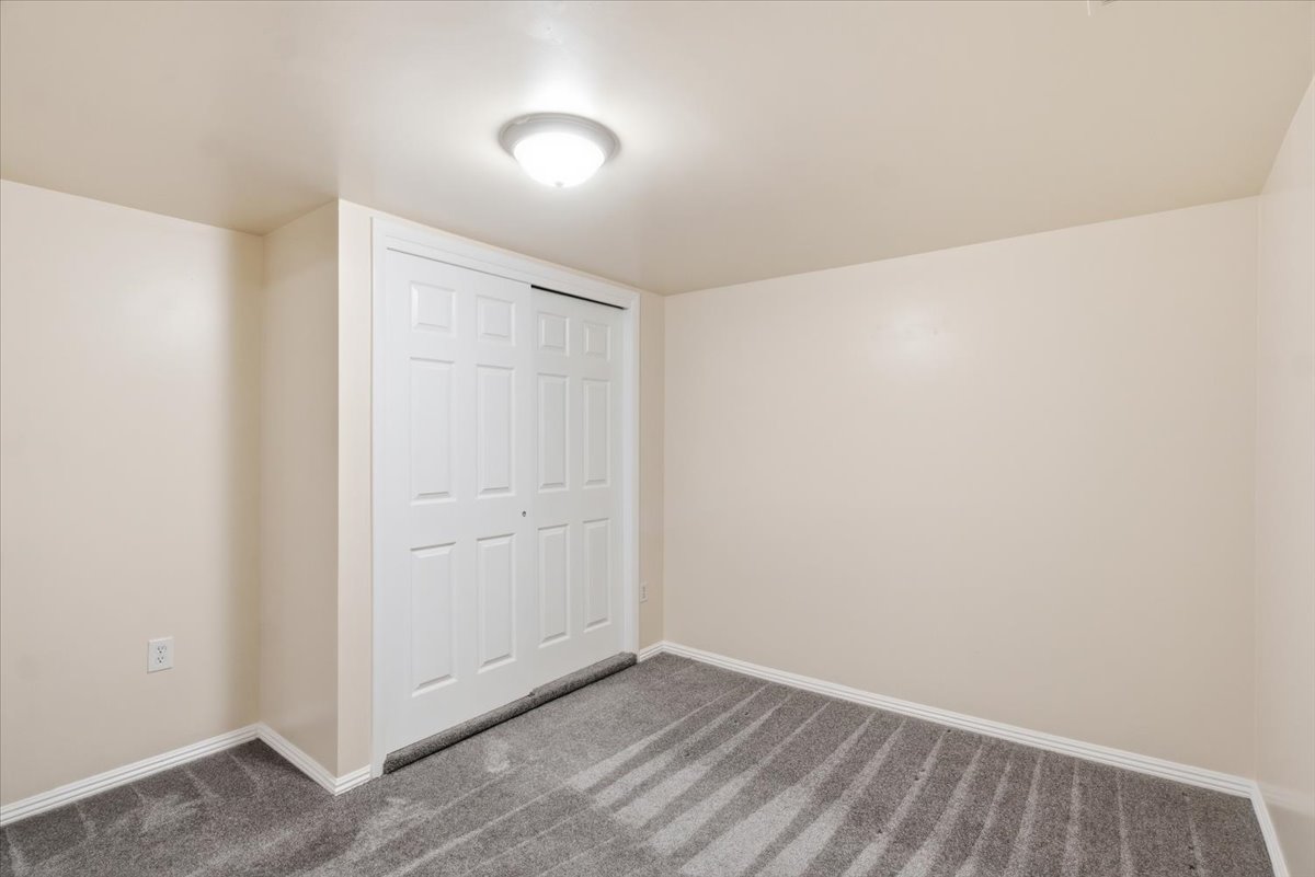 Neutral-toned interior room featuring light beige walls and a patterned gray carpet