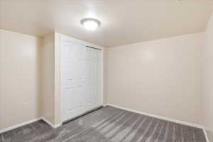 Neutral-toned interior room featuring light beige walls and a patterned gray carpet