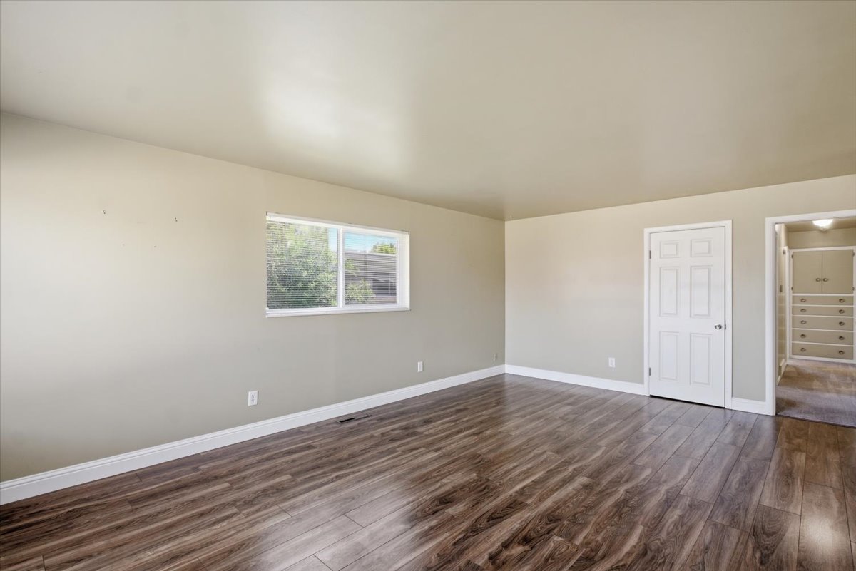 Spacious interior featuring wood-finish flooring, light neutral wall paint, and white trim