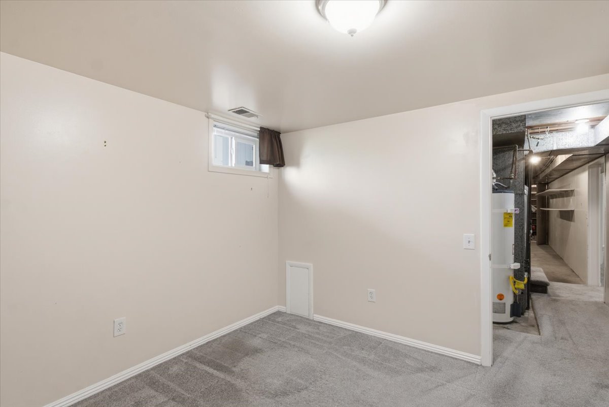 Carpeted room featuring a white-trimmed window, light-toned walls, and a flush-mount ceiling light