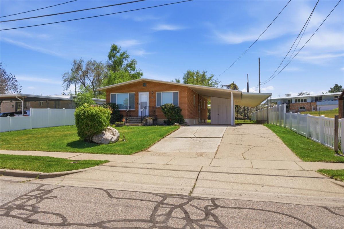 Brick exterior with a covered carport and a paved driveway