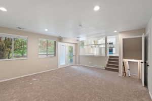 Spacious lower-level area featuring plush carpeting, recessed lighting, and ample natural light from multiple windows