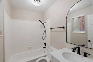 Full bathroom featuring a white tile shower surround, a built-in tub, and a vanity with a white countertop