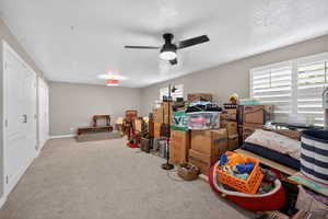 Spacious room featuring neutral paint, light-colored carpeting, and a ceiling fan