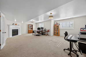 Spacious room featuring a white mantel fireplace, recessed lighting, and a drum pendant light fixture