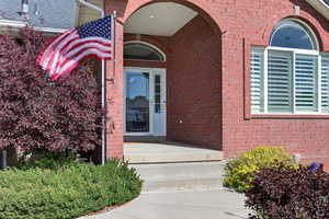 Brick exterior with an arched entry, transom window, and white door with sidelights