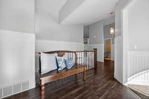 Inviting entryway featuring dark wood-finish flooring and white wainscoting