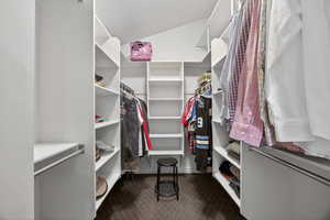 Custom closet system featuring multiple hanging rods, extensive shelving, and angled ceiling lines