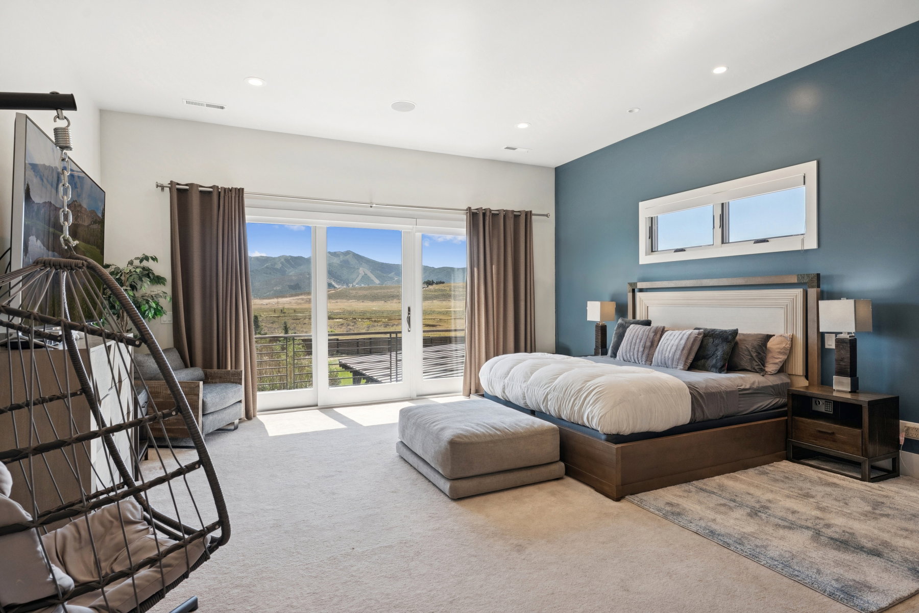 Expansive room featuring sliding glass doors opening to a mountain landscape