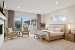 Spacious room featuring light-colored carpeting, recessed lighting, and a large fireplace with a mounted television