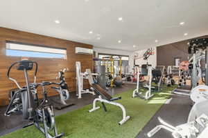 Dedicated fitness space featuring recessed lighting, a wood-finish accent wall, and a horizontal window