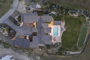 Expansive estate featuring a large swimming pool, paved patio, fire pit area, and a putting green