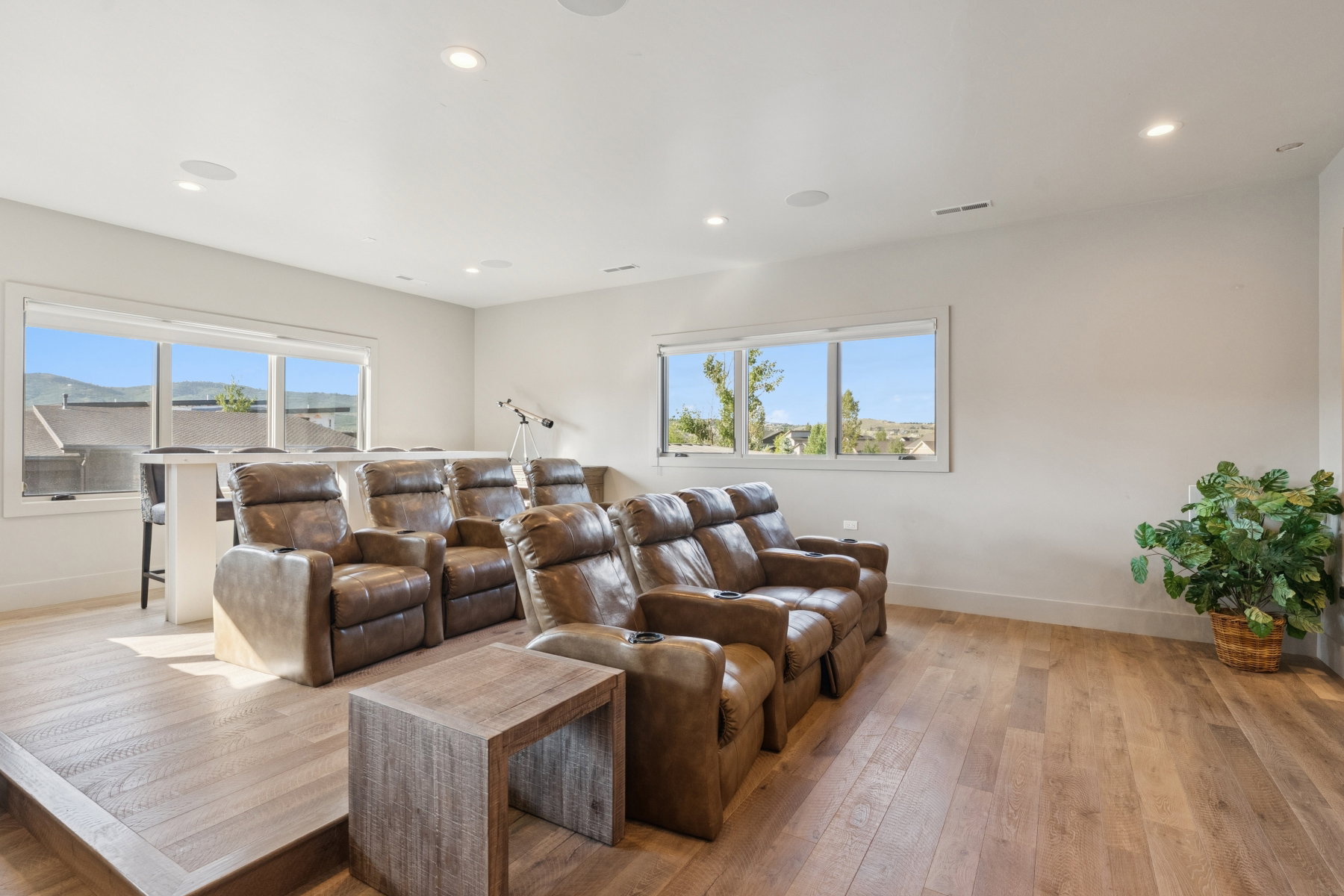Dedicated entertainment room featuring a raised platform, wood-finish flooring, and recessed lighting
