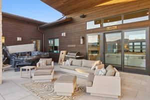 Expansive outdoor patio featuring a built-in hot tub, an outdoor grill station, and wood-finish siding
