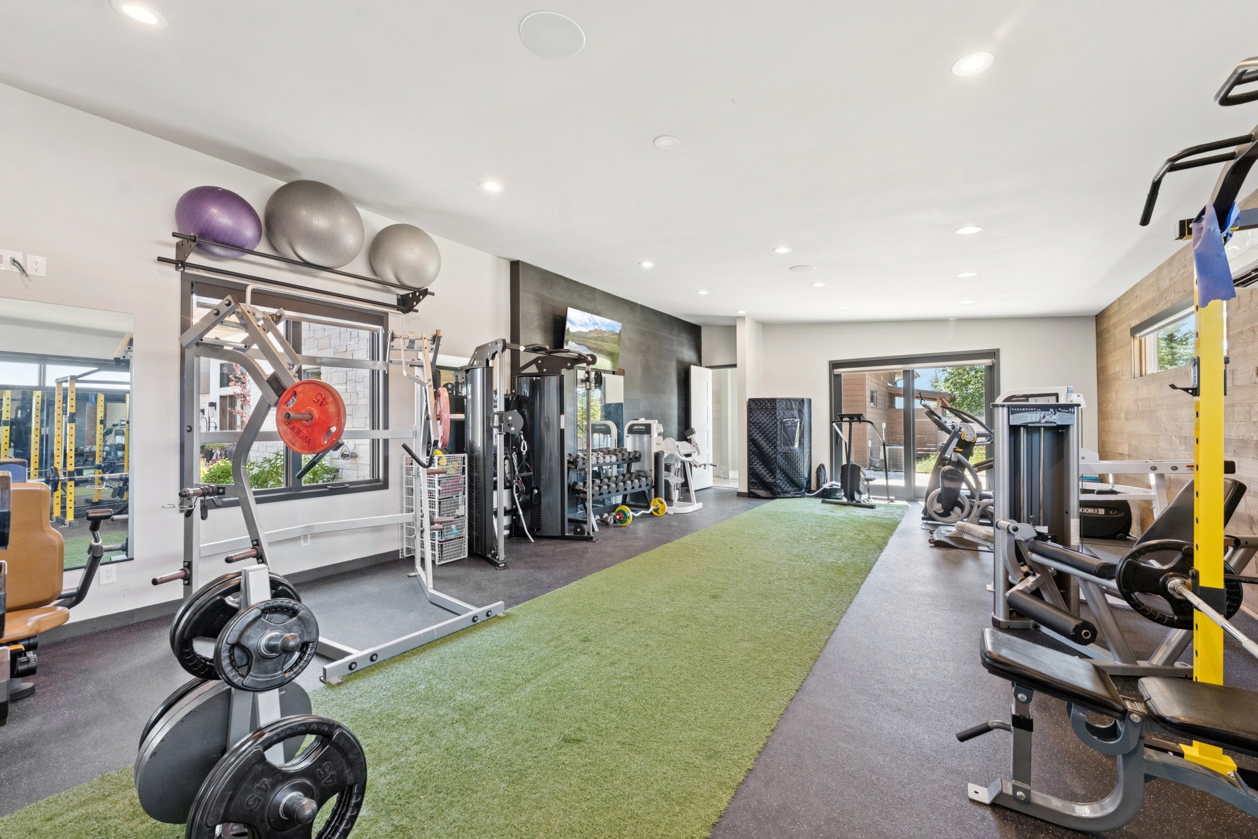 Dedicated fitness room featuring recessed lighting, a turf-style floor section, and black rubber flooring