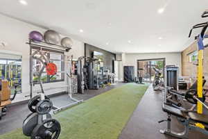 Dedicated fitness room featuring recessed lighting, a turf-style floor section, and black rubber flooring