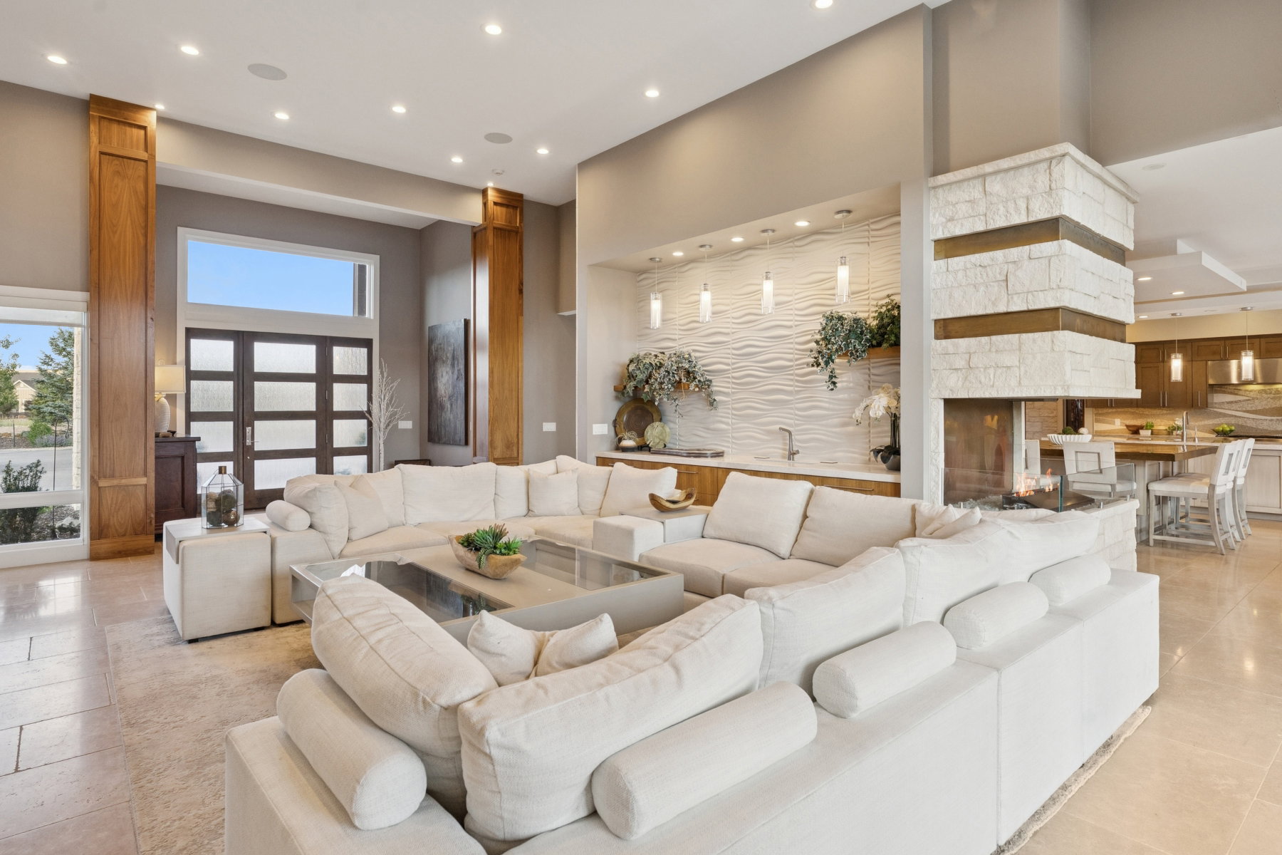 Expansive living area featuring light-toned tile flooring and recessed lighting